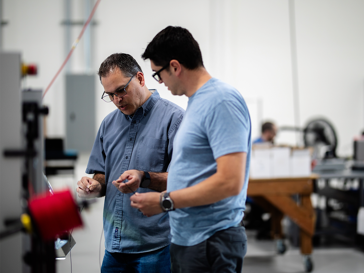 two men reviewing cables and conversing about how to improve cable quality. Precision Cables.