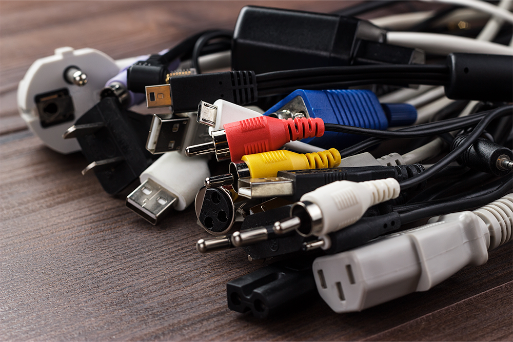 overmolded cables of different colors and adaptors. all laid out on a wooden table. Precision Cables